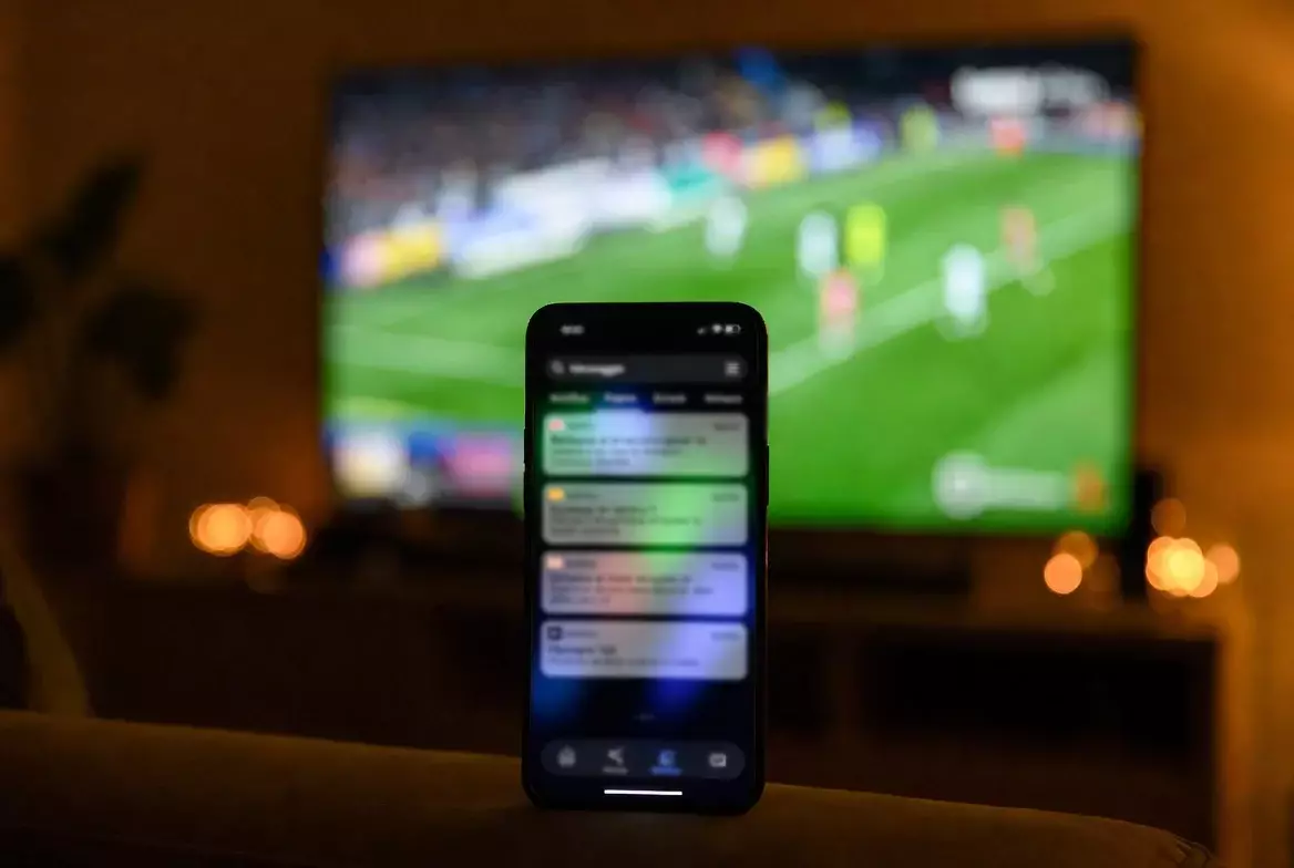 Smartphone con partita in diretta e notifiche multiple